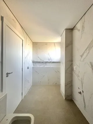 Corredor interno com revestimento em mármore nas paredes.