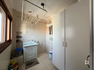 Banheiro com revestimento cerâmico e armários brancos.