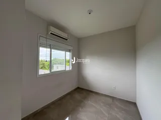 Ambiente interno de uma sala com janela e ar condicionado.