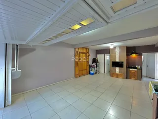 Imagem de uma área interna com piso de cerâmica clara e forro de gesso.