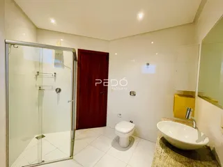 Foto de um banheiro com box de vidro e piso cerâmico.