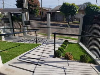 Foto de uma área externa com piso de concreto e gramado em um imóvel.