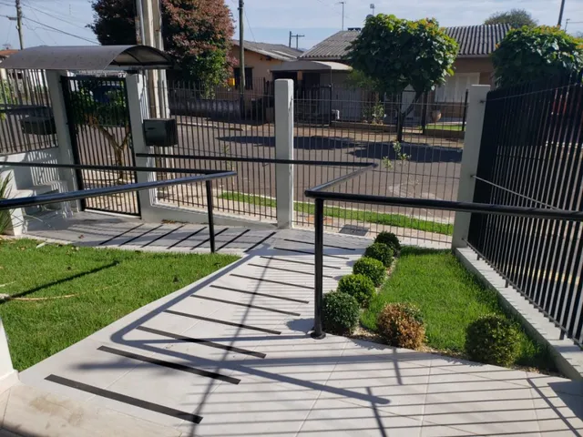 Foto de uma área externa com piso de concreto e gramado em um imóvel.