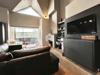 Sala de estar moderna com grande janela e vista para o exterior.