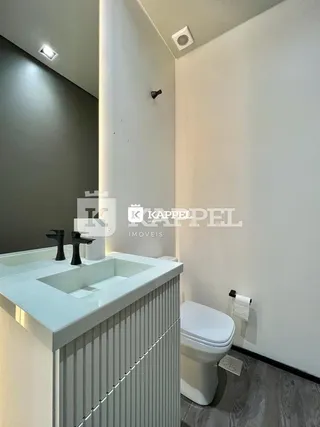 Foto de um banheiro com bancada branca e vaso sanitário.