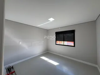 Foto de um cômodo interno vazio com paredes brancas e piso claro.