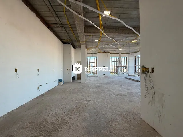 Foto de um espaço interno amplo e em construção com estrutura exposta.