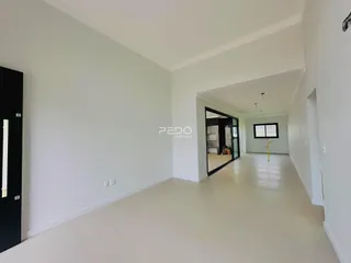 Vista interna de um ambiente com paredes brancas e piso claro.