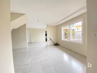 Vista de um corredor interno com piso de cerâmica clara.