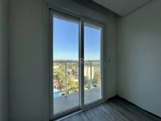 Ambiente interno com porta de vidro que oferece uma vista para o exterior.