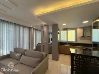 Sala de estar moderna com iluminação clara e grandes janelas.
