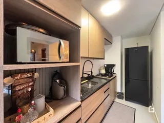 A cozinha apresenta armários de madeira e eletrodomésticos modernos.