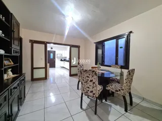 Sala de estar com mesa de jantar e vista para a cozinha em um imóvel no Brasil.