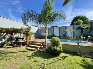 Vista externa de uma área de jardim com piscina e deck em Lajeado, Brasil.