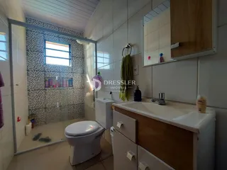 Banheiro com box de vidro e revestimento cerâmico.