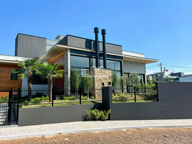 Fachada moderna de uma residência em Lajeado, Brasil, com cerca e jardim.