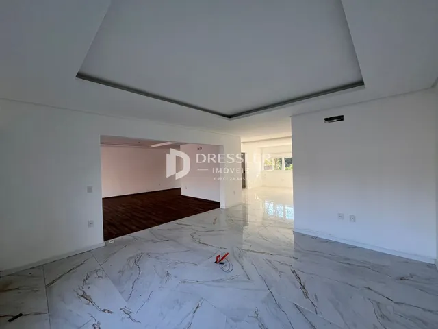Vista interna de um ambiente com piso de mármore claro e paredes brancas.