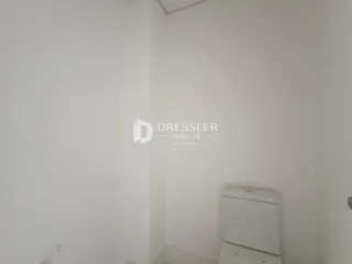 Parede branca de um interior com um vaso sanitário visível.
