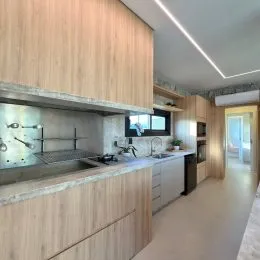 Foto de uma cozinha com armários de madeira clara e bancada.