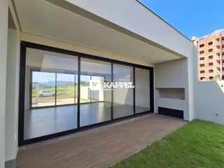 Vista da fachada de uma residência moderna com grandes portas de vidro.