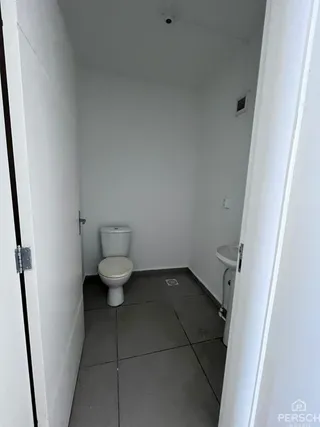 Foto de um banheiro simples com piso de cerâmica e paredes brancas.
