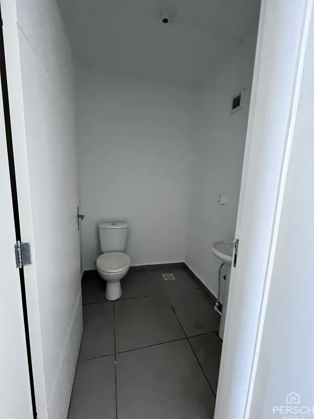 Foto de um banheiro simples com piso de cerâmica e paredes brancas.