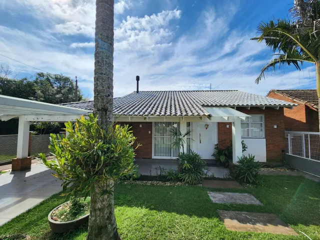 Foto da fachada de uma casa em Lajeado, Brasil, com telhado de telhas e jardim frontal.