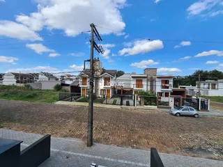 Fachada de casas residenciais em Lajeado, Brasil, com área pavimentada na frente.
