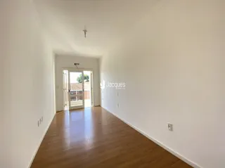 Corredor interno com piso de madeira clara em uma residência.