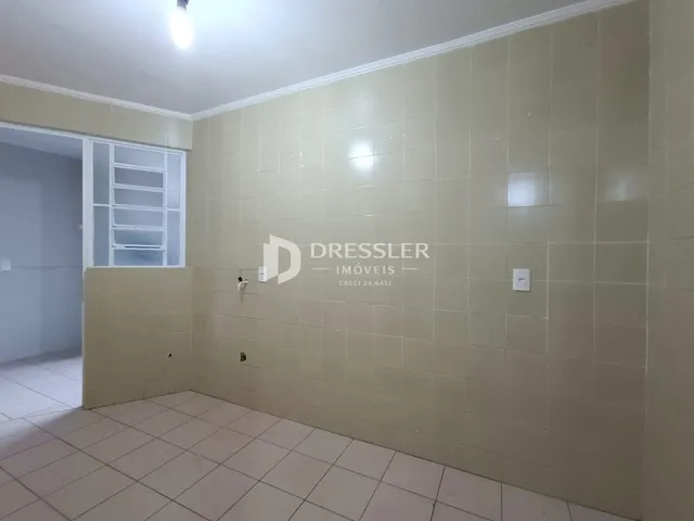 Parede interna com revestimento cerâmico claro em um imóvel.