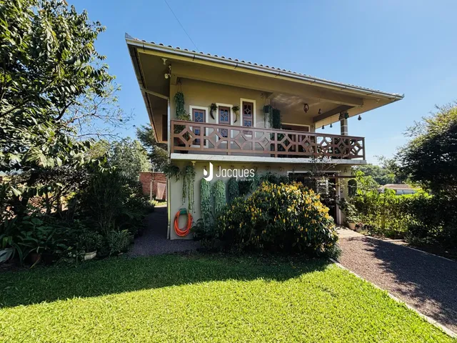 Fachada de uma casa em Lajeado, Brasil, com jardim exuberante e varanda.