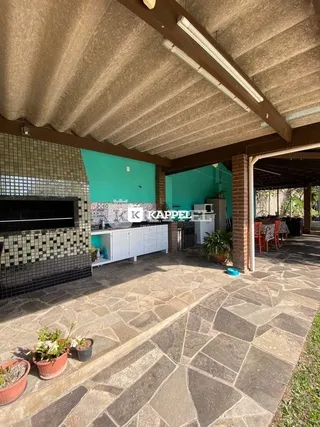 Foto de uma área coberta com revestimento de azulejos e piso de pedra.
