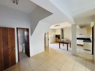 Vista interna de uma sala com acesso a um banheiro e cozinha em um imóvel no Brasil.