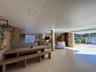 Interior moderno de uma sala de estar com piso claro e detalhes em madeira.
