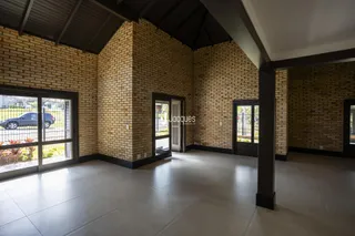 Ambiente interno com paredes de tijolo aparente e piso de cerâmica.