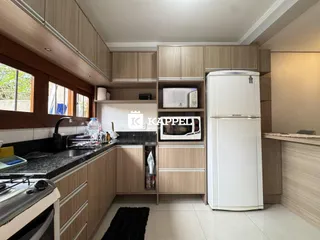 Cozinha moderna com armários de madeira e bancadas escuras.