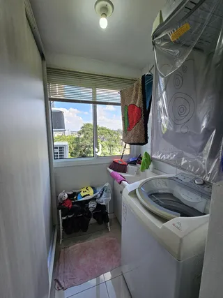 Foto de uma área de serviço com máquina de lavar e janela com vista para o exterior.