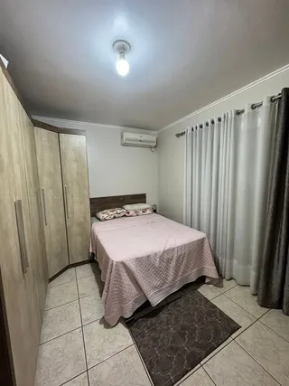 Quarto com cama e armário em um ambiente claro.