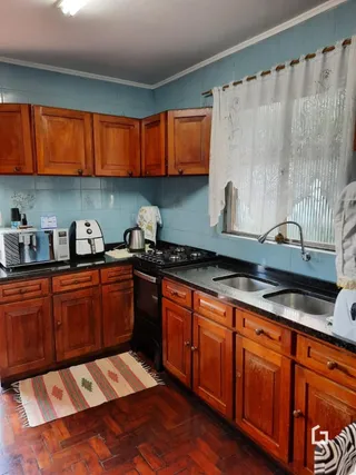 Uma cozinha com armários de madeira e piso de madeira.