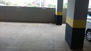 Vista externa de uma área pavimentada com pilares de concreto.