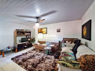 Sala de estar com sofá, estante de livros e televisão.