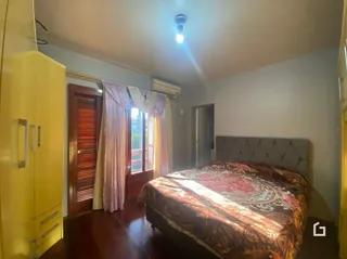 Quarto com cama e cortinas em madeira.