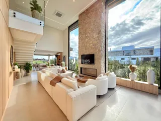 Sala de estar moderna com grandes janelas e vista externa.
