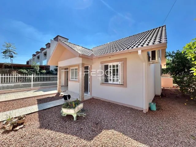 Fachada de uma casa residencial em Lajeado, Brasil, com muro branco e telhado de telhas.