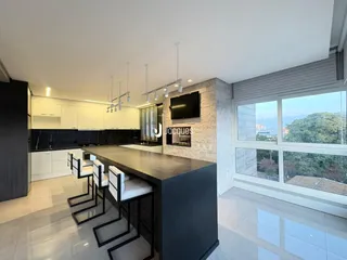 Vista de uma cozinha moderna com ilha e grande janela em Lajeado.