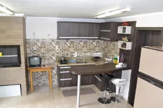 Cozinha com armários de madeira e revestimento cerâmico.