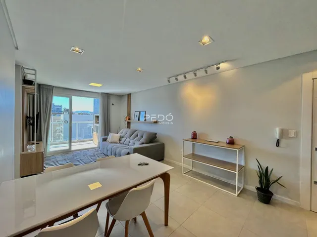 Sala de estar com vista para a cidade e área de jantar em um imóvel no Brasil.