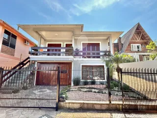 Fachada de uma casa em Lajeado, Brasil, com portão de ferro e cerca.