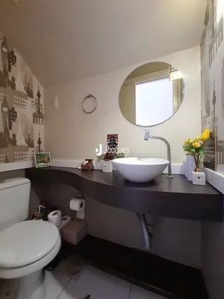 Foto de um banheiro interno com pia e vaso sanitário.