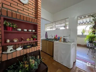 Interior de uma sala de estar com parede de tijolos aparentes e estantes.